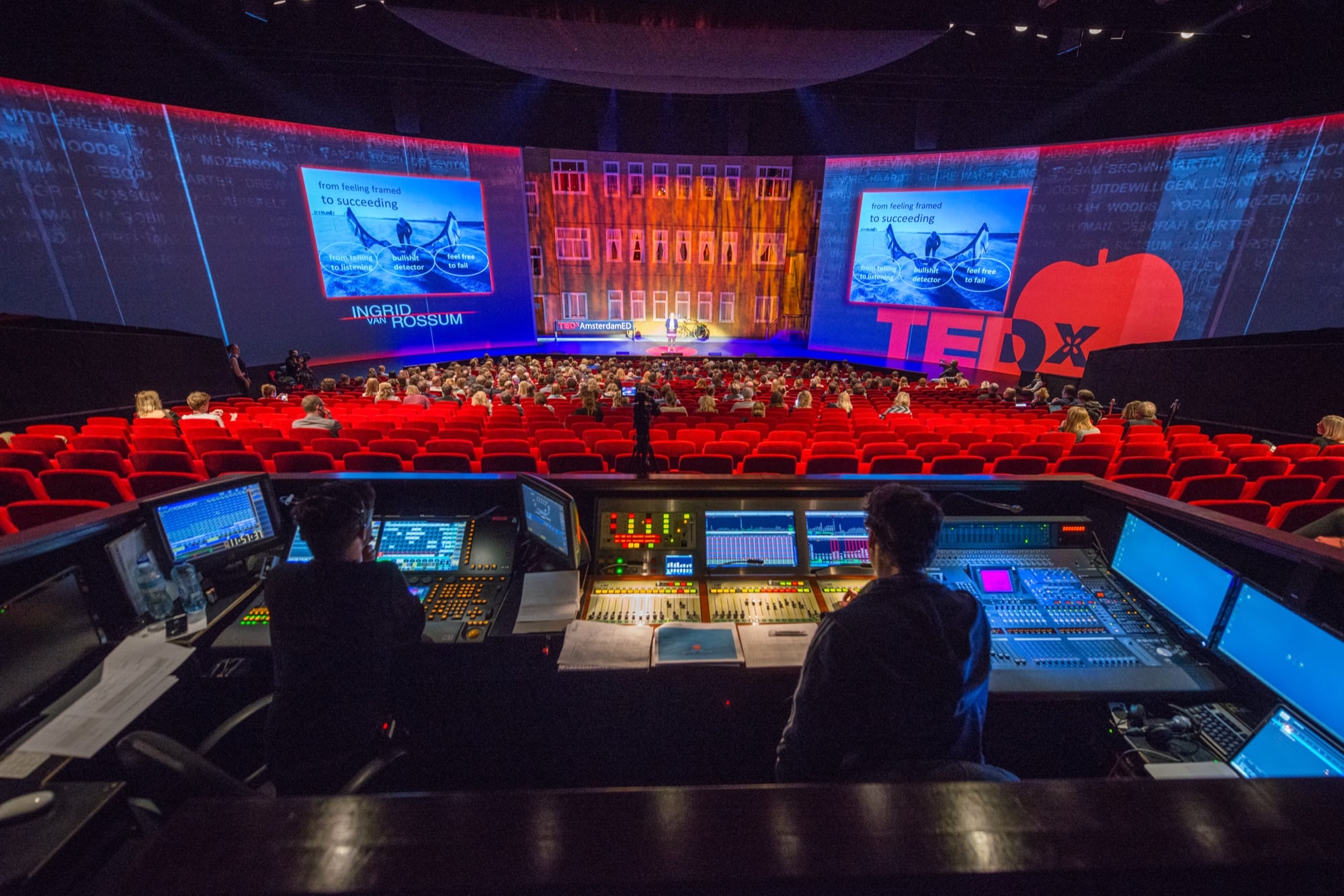 A full auditorium at TEDxAmsterdamED, seen from the lighting and sound desk at the back of the room
